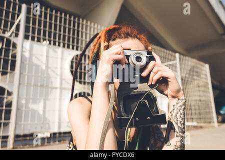 Junges Mädchen mit Tattoo und dreadlocks Bilder auf städtischen industriellen Hintergrund geschieht. Stockfoto