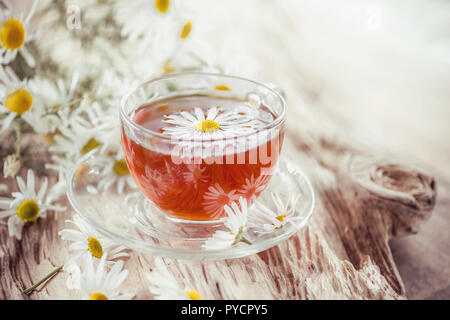 Eine klare Schale von Arzneimitteln Kamille Tee auf einem alten Holztisch. Gesundheit und gesunder Lebensstil Konzept. Stockfoto