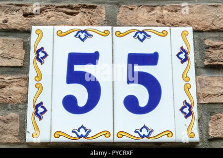 Haus Nummer 55 55 auf Keramik in Blau und Gelb, Rot und Gold aus Schweden lackiert Stockfoto