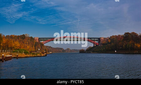 Nord-Ostsee-Kanal, alte Levensauer Hochbrücke', Kiel. Deutschland. Deutschland. Es ist Herbst und die Bäume an den Ufern des Kanals sind die Farben des Herbstes, reich an Rot-, Braun- und Gelbtönen. Diese reichen Farben sind, die von der Sonne auf der linken Kanalufer gebracht und das Wasser ist voll von Reflexionen. Stockfoto