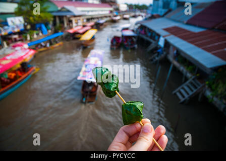 Wickelte Ming kham auf einem Stock Thai Food, über dem Wasser Kanal von schwimmenden Markt Amphawa, Thailand Stockfoto