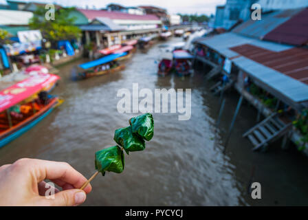 Wickelte Ming kham auf einem Stock Thai Food, über dem Wasser Kanal von schwimmenden Markt Amphawa, Thailand Stockfoto