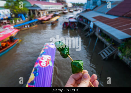 Wickelte Ming kham auf einem Stock Thai Food, über dem Wasser Kanal von schwimmenden Markt Amphawa, Thailand Stockfoto