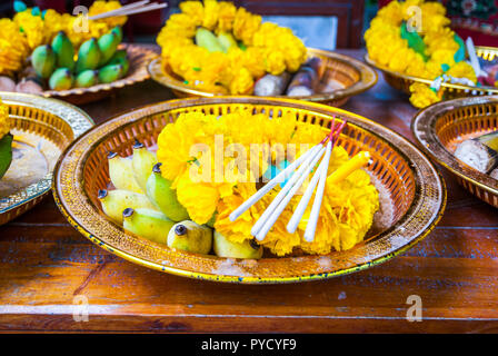 Buddhistische Angebote von Blumen, Weihrauch, Bananen und Reis auf einen Teller in den Tempel, Nahaufnahme, Thailand Stockfoto