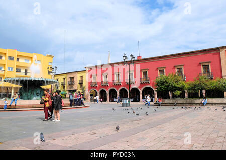 Plaza Fundadores in León, Guanajuato, Mexiko, mit dem traditionellen Brunnen und gewölbte Durchgänge, die angrenzenden Gebäude schmücken. Stockfoto