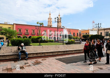 Plaza Fundadores in León, Guanajuato, Mexiko, mit dem traditionellen Brunnen und gewölbte Durchgänge, die angrenzenden Gebäude schmücken. Stockfoto