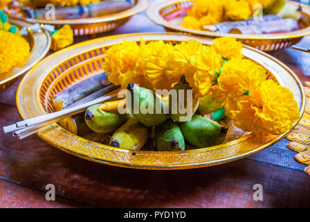 Buddhistische Angebote von Blumen, Weihrauch, Bananen und Reis auf einen Teller in den Tempel, Nahaufnahme, Thailand Stockfoto