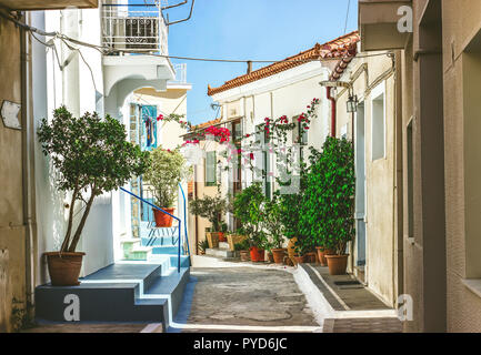 Die engen Gassen der Stadt Neorio in Poros Island, Griechenland; alte weiße Häuser mit Blumen Stockfoto