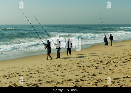 Durban, KwaZulu-Natal, Südafrika, Gruppe von fünf erwachsenen Männern holding Angelruten warten auf Streik am Sandstrand in der Nähe der Bremsen Wellen, den Bluff Stockfoto