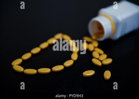 Blick von oben auf die Buchstaben D mit gelben pharmazeutischen Pillen Stockfoto