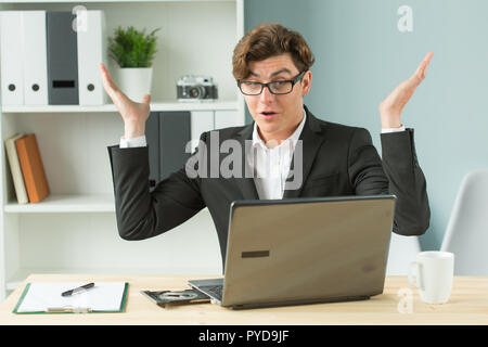 Technologien, Emotionen und Business Personen Konzept - schöner Mann seine Hände ausbreitet, während er am Computer arbeitet, denn er hat einige Probleme mit Internetverbindung Stockfoto
