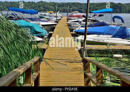 Kleine Pier (Sutter's Marina) mit Booten in Irondequoit Bay, einer schmalen Bucht des Lake Ontario, New York State, USA angeschlossen Stockfoto