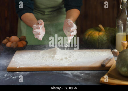 Hände kneten den Teig von Frauen. Backzutaten auf hölzernen Tisch Kürbis Milch Öl Mehl Kopie Raum Stockfoto