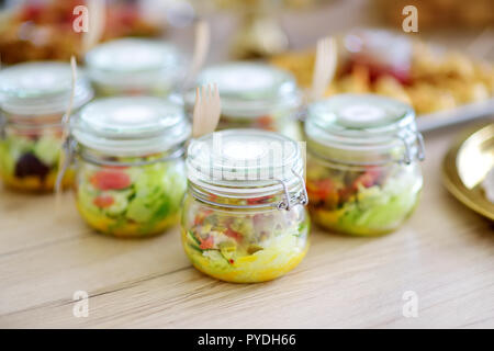 Frisch und lecker Salat serviert in mini Gläser auf einer Party oder Hochzeit. Platten mit sortierten fancy Finger Food Snacks auf ein Ereignis par Stockfoto