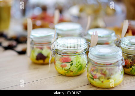 Frisch und lecker Salat serviert in mini Gläser auf einer Party oder Hochzeit. Platten mit sortierten fancy Finger Food Snacks auf ein Ereignis par Stockfoto