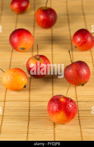 Fresh mini rote Äpfel auf dem Stroh Hintergrund Stockfoto