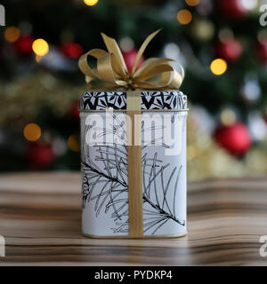 Niedlich und stilvolle Weihnachtsgeschenk. Das Geschenk ist auf einem hölzernen Oberfläche und es ist eine schöne, bunte Weihnachten drei mit viel Dekoration. Stockfoto