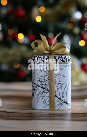 Niedlich und stilvolle Weihnachtsgeschenk. Das Geschenk ist auf einem hölzernen Oberfläche und es ist eine schöne, bunte Weihnachten drei mit viel Dekoration. Stockfoto