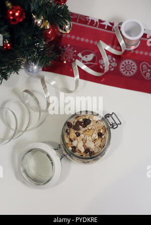 Hausgemachte Weihnachten Müsli in einem Glas. Es gibt einen Weihnachtsbaum und anderen Dekorationen im Hintergrund. Frohe Weihnachten! Stockfoto