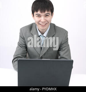 Junge Unternehmer vor einem offenen Laptop. auf weißem Hintergrund Stockfoto