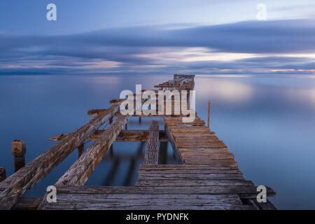 Alte aufgeschlüsselt hölzernen Pier in Punta Arenas, alte Dock in Chile am Pazifik. Sonnenuntergang Stockfoto