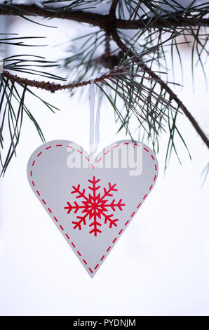 Dekoration aus Holz in der Form eines Herzens. Weihnachten Dekoration in der Form eines Herzens auf einem mit Pinien. Stockfoto