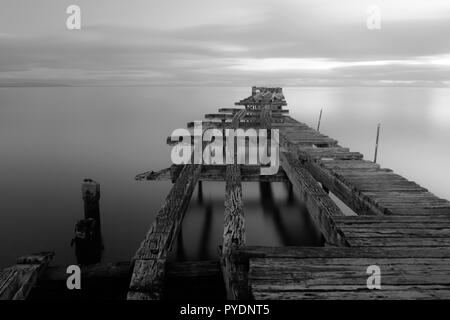 Alte aufgeschlüsselt hölzernen Pier in Punta Arenas, alte Dock in Chile am Pazifik. Sonnenuntergang Stockfoto