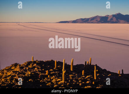 Blick auf den Sonnenaufgang über der Insel Incahuasi durch Salzsee Uyuni in Bolivien. Straße in der Salar Stockfoto