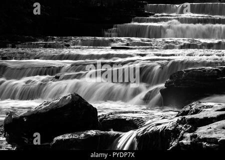 Die rohe Kraft des Wassers über Kalkstein Schritte bei geringeren Kraft, Aysgarth, Wensleydale, Yorkshire. Großbritannien Stockfoto