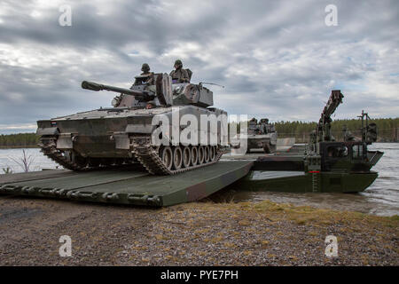 Die deutschen Soldaten aus der 2. Firma multinationalen Engineer Battalion der Sehr hohe Bereitschaft, Joint Task Force (VJTF) durch den Fluss zu überqueren, Training auf dem Fluß Rena mit amphibischen Fähre Fahrzeuge M3. Überquerung der niederländischen Panzergrenadier Kampffahrzeugen CV 90. NATO-Übung Trident Punkt in Norwegen, Rena am 24. Oktober 2018. Foto: SGM Marco Dorow, Bundeswehr Stockfoto