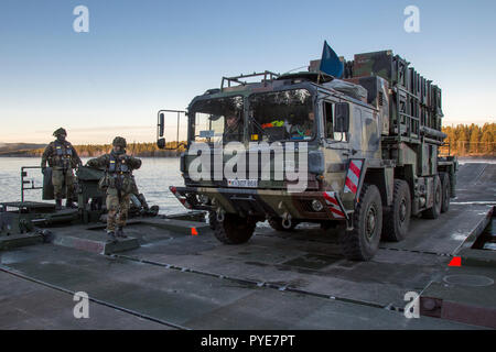 Die deutschen Soldaten aus der 2. Firma multinationalen Engineer Battalion der Sehr hohe Bereitschaft, Joint Task Force (VJTF) durch den Fluss zu überqueren, Training auf dem Fluß Rena mit amphibischen Fähre Fahrzeuge M3. Crossing Over-Rakete (SAM) System Patriot aus der deutschen Luftwaffe. NATO-Übung Trident Punkt in Norwegen, Rena am 24. Oktober 2018. Foto: SGM Marco Dorow, Bundeswehr Stockfoto