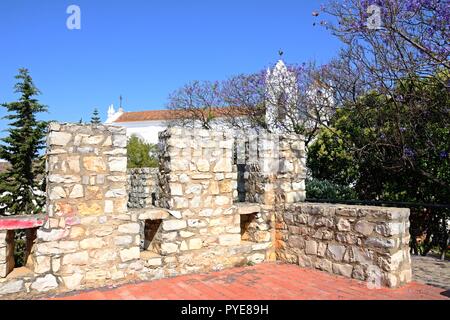 Ansicht des Schlosses Zinnen mit St Marys Kirche (Igreja de Santa Maria do Castelo) nach hinten, Tavira, Algarve, Portugal, Europa. Stockfoto