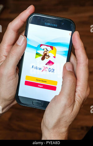 Vatikan gibt die Smartphone App' Folgen JC GEHEN!" (Jesus Christus), die fast an das Modell Pokémon Gehen identisch. Anstelle von Monster, Heiligen sind jetzt gesucht und im Vatikan Spiel erwischt. Das Spiel ist derzeit nur verfügbar in Spanisch, andere Sprachversionen werden in Kürze veröffentlicht. Foto zeigt die Login Seite des 'Folgen JC GO!' auf einem Smartphone. Stockfoto