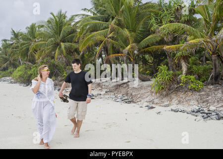 Glückliches junges Paar entlang einer wunderschönen tropischen Sandstrand. Flitterwochen auf einer exotischen Insel. Hochzeitsreise schönes Paar auf einer exotischen Strand. Kuppl Stockfoto