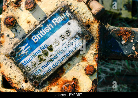 Korrodierte British Rail Identifikation Seriennummernschild auf eine alte rostige Stück von Maschinen in einem Schrottplatz, England, Großbritannien Stockfoto