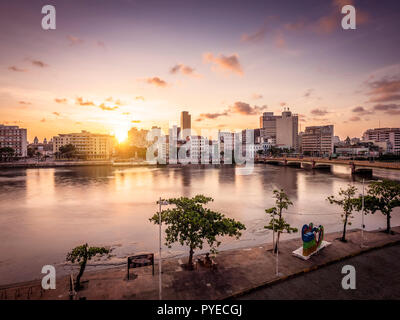 Recife in Pernambuco, Brasilien durch den Fluss Capibaribe mit Gebäuden aus der Kolonialzeit und den Sonnenuntergang. Stockfoto