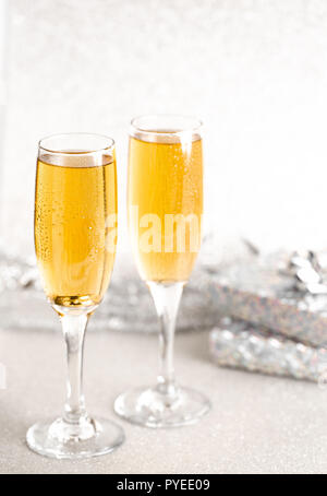 Zwei Gläser Champagner auf silbernem Glitzer Hintergrund Stockfoto