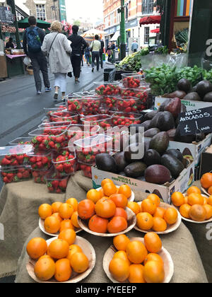 London, Großbritannien - 19 Oktober, 2018: die Menschen zu Fuß vorbei an einer wunderschönen Obst und Gemüse auf einem Markt in London ausgeht. Stockfoto