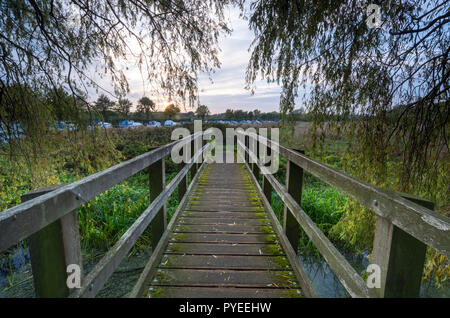 Ein Holzsteg Brücke über den Fluss Nene an orton bloße oder orton Schloss an der nene Pfad, nene Gleichheit in der Nähe von Peterborough, Cambridgeshire Fens. Stockfoto