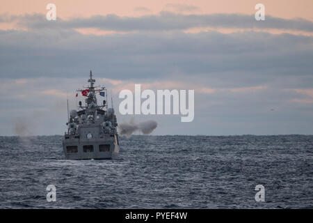 Türkische Marineschiff Oruceis feuert seine wichtigste Waffe beim Segeln vor Her Majesty's Canadian Ship Ville de Québec, während in der Nähe der Küste von Norwegen während der Übung Trident Zeitpunkt am 26. Oktober 2018. Foto: MCpl Andre Maillet, MARPAC Imaging Services Stockfoto