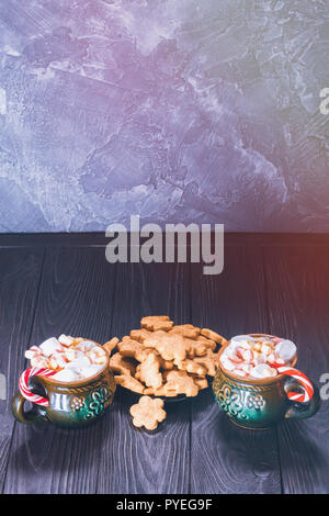 Zwei Tassen auf den Tisch voller Marshmallows und Keks Plätzchen auf einer Platte mit einer Kopie Raum Stockfoto