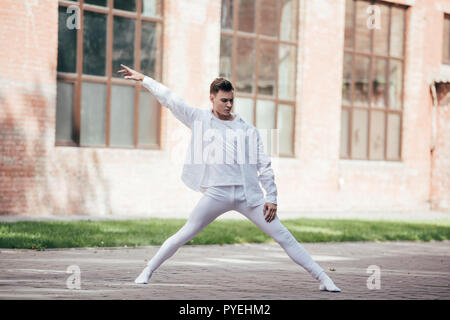 Hübscher junger Tänzer performing Modern Dance auf der Straße Stockfoto