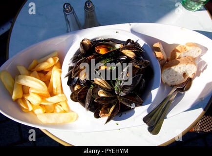 Moules Mariniere mit Chips, in der Konservenindustrie des Cyclistes, Honfleur, Normandie serviert. Stockfoto