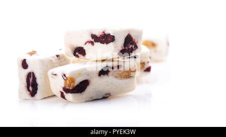 Sorft weißer Nougat mit Mandeln und Preiselbeeren auf weißem Hintergrund Stockfoto