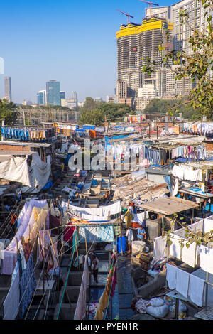 Ein open air Wäsche in den Slums von Mumbai, Indien, durch in der Nähe Wolkenkratzer in den Schatten gestellt. Stockfoto