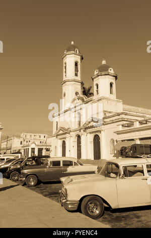 CIENFUEGOS, Kuba - 3. JANUAR 2017: Oldtimer in Jose Marti Park, dem Hauptplatz von Cienfuegos, vor dem Purisima Concepcion Kathedrale. Cie Stockfoto