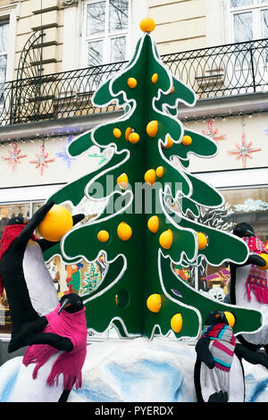 Lemberg, Ukraune - 24. Dezember 2017: Street Installation große Spielzeug Pinguine in der Nähe von Weihnachten Baum mit Orangen eingerichtet. Neue Jahre Ausstellung Stockfoto