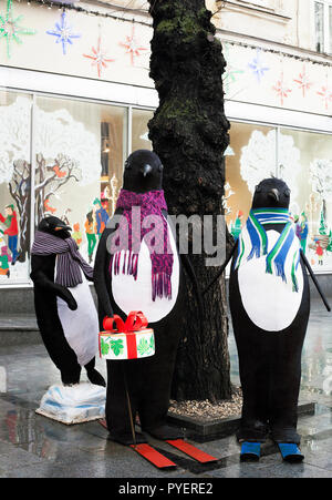 Lemberg, Ukraune - 24. Dezember 2017: Street Installation große Spielzeug Pinguine in der Nähe von Bäumen. Weihnachten Ausstellung in der Nähe von Roshen сandy Store Stockfoto