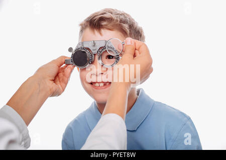 Kleiner Junge, in seinen Augen zu untersuchen. Kinder Auge Prüfungsverfahren mit Trial Rahmen Stockfoto