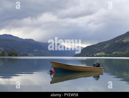 Single Motor Boot auf dem See Vagavatnet in Vagamo in Norwegen. Norwegischen Fjord und die Berge im Hintergrund. See haben schöne Reflexionen. Stockfoto